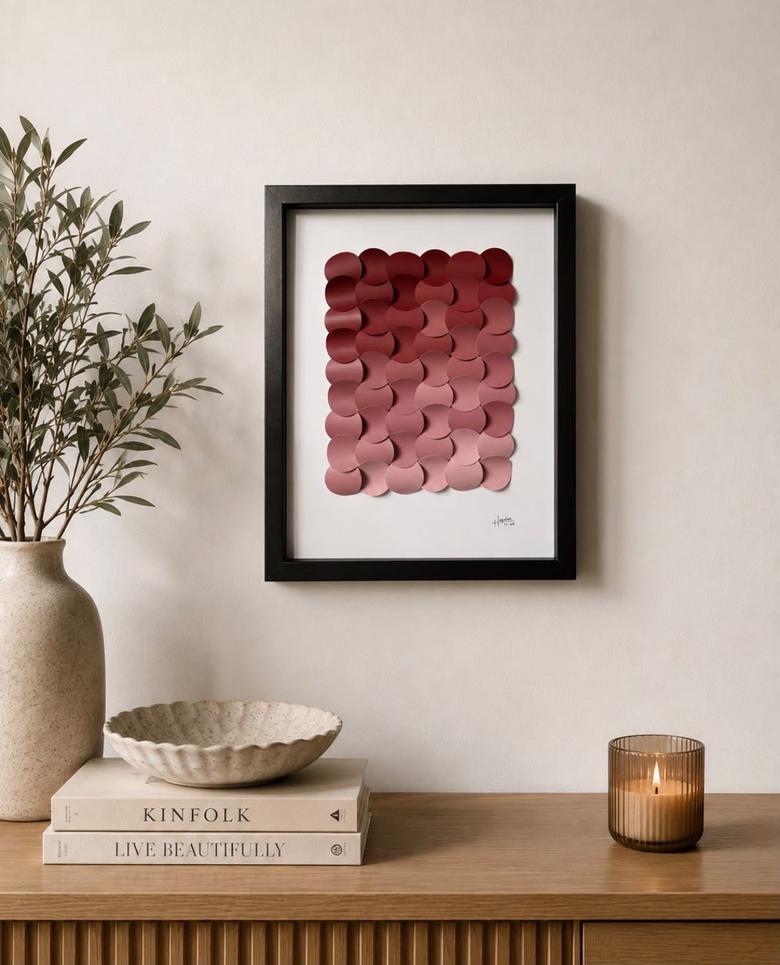 Framed paper piece in mauve and pink styled on a console
