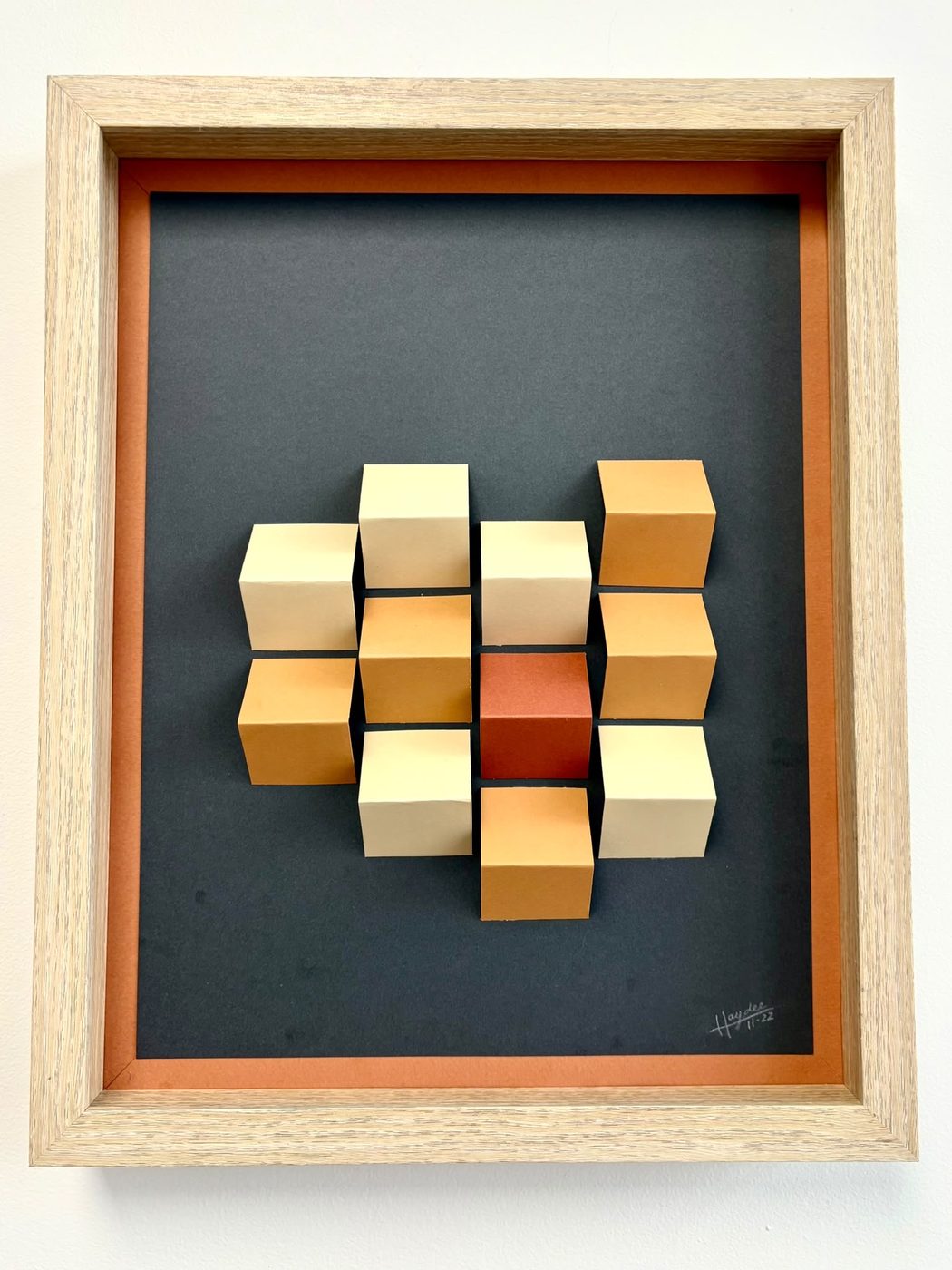 Framed 3D cube wall piece in an orange and gold diamond pattern