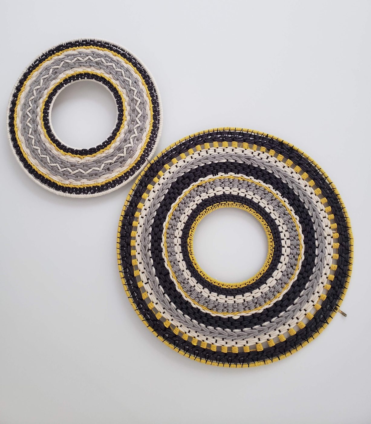 Pair of woven circular wall pieces in grey and yellow